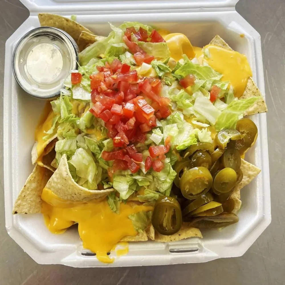 Gage's Supreme Nachos loaded with cheese, lettuce, tomato, and jalapeños