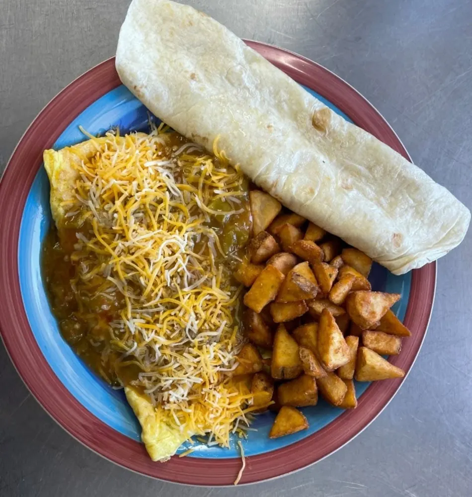 Green chili cheese omelet-style plate with potatoes and a flour tortilla