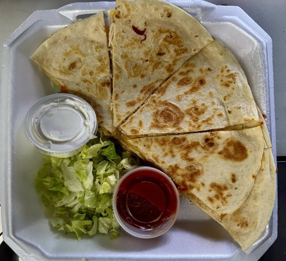 Alejandra's Quesadilla cut into wedges with lettuce and salsa